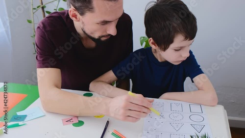 Autism boy during therapy with his school tutor, learning together. Autism childhood mental illness therapy concept