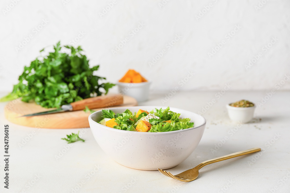 Bowl of fresh salad with vegetables on light background - obrazy, fototapety, plakaty 