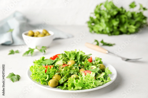 Plate of fresh salad with vegetables on light background