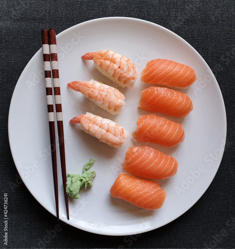 Gourmet sushi made with salmon and shrimp on a white plate