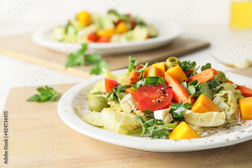 Plates of fresh salad with vegetables on light wooden background