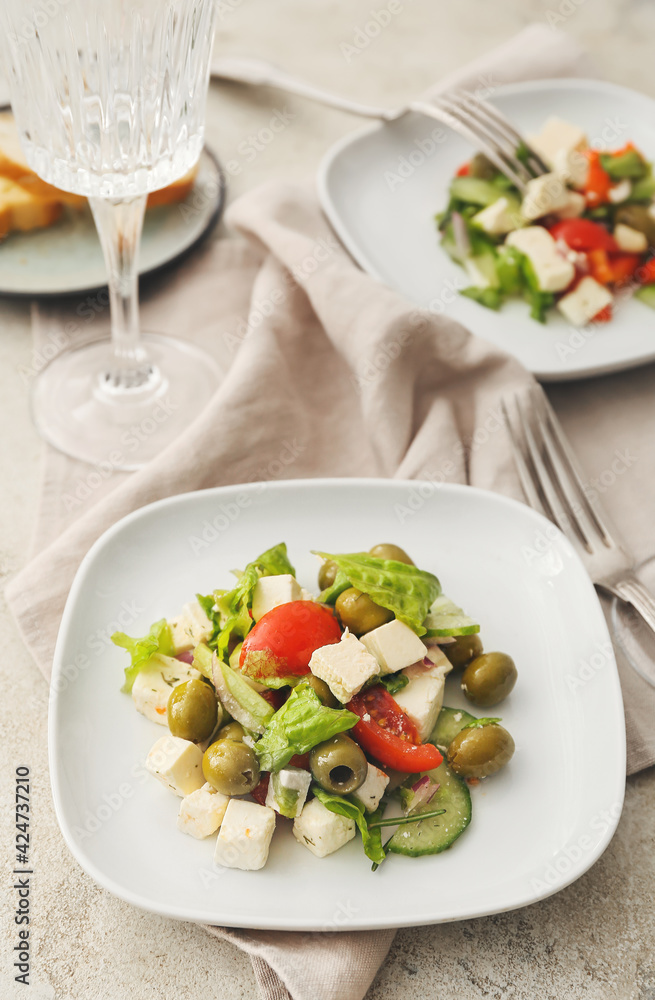 Plates with fresh Greek salad on light background Plates with fresh Greek salad on light background