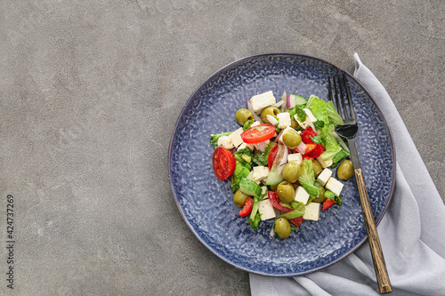 Plate with fresh Greek salad on grunge background