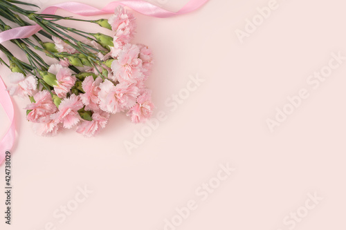 Design concept of Mother's day holiday greeting with carnation bouquet on pink table background