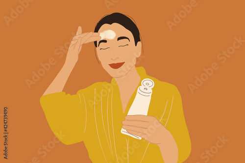 Pretty woman apply cream or scrub on face in yellow bathrobe while holding a tube. Clean and beauty skincare. Vector Illustration.