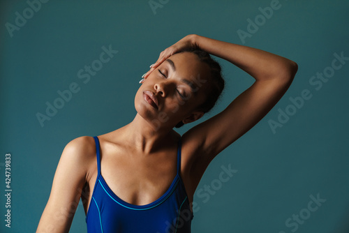 Young black swimmer stretching her neck while working out © Drobot Dean