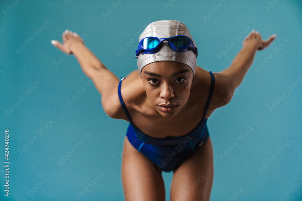 Young black swimmer in goggles doing exercise while working out