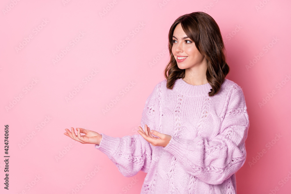 Portrait of attractive cheerful wavy-haired girl holding on palms copy space isolated over pink pastel color background Portrait of attractive cheerful wavy-haired girl holding on palms copy space isolated over pink pastel color background
