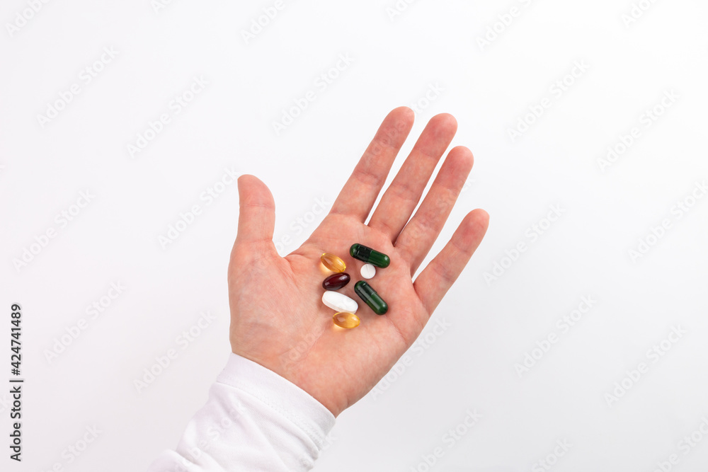 vitamins and nutritional supplements on palm, white background vitamins and nutritional supplements on palm, white background
