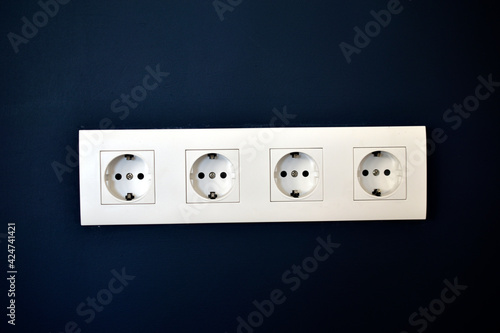 White electrical outlets on a blue wall with Internet connectors