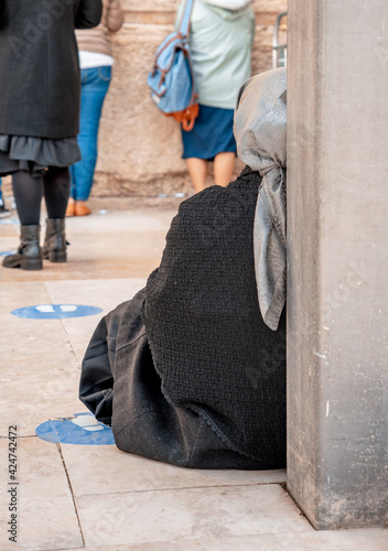 Religious jewish woman sits at a column near the Wailing Wall. Jerusalem, Israel (599)