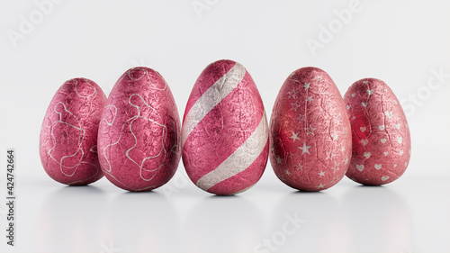 Easter Eggs isolated against a white background. Chocolate Eggs wrapped in patterned Pink and Silver foil. 3D Render photo