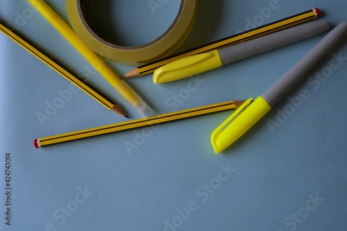 Yellow stationery on blue background. Flat lay with office supplies in yellow shades. School materials
