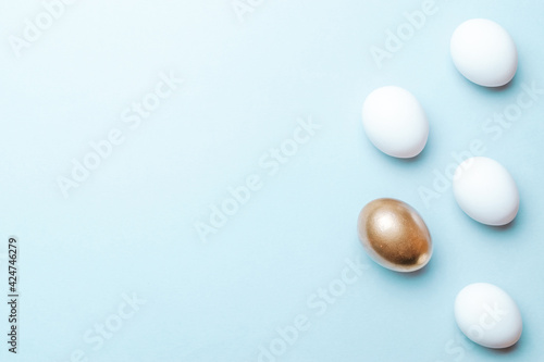 Easter flat. Golden  white colour egg on pastel blue background in Happy Easter decoration. Spring holiday top view concept.