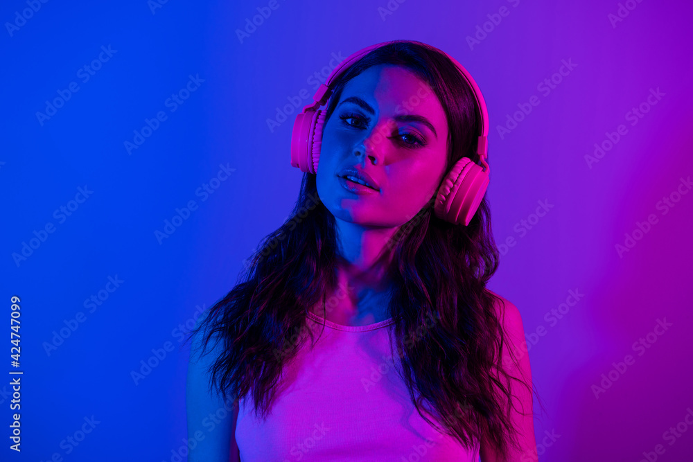 Photo of beautiful gorgeous stunning young woman in headphones nightclub party isolated on neon blue color background