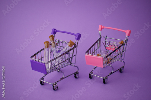 Two toy shopping baskets with small glass bubbles on a purple background. Shopping carts.