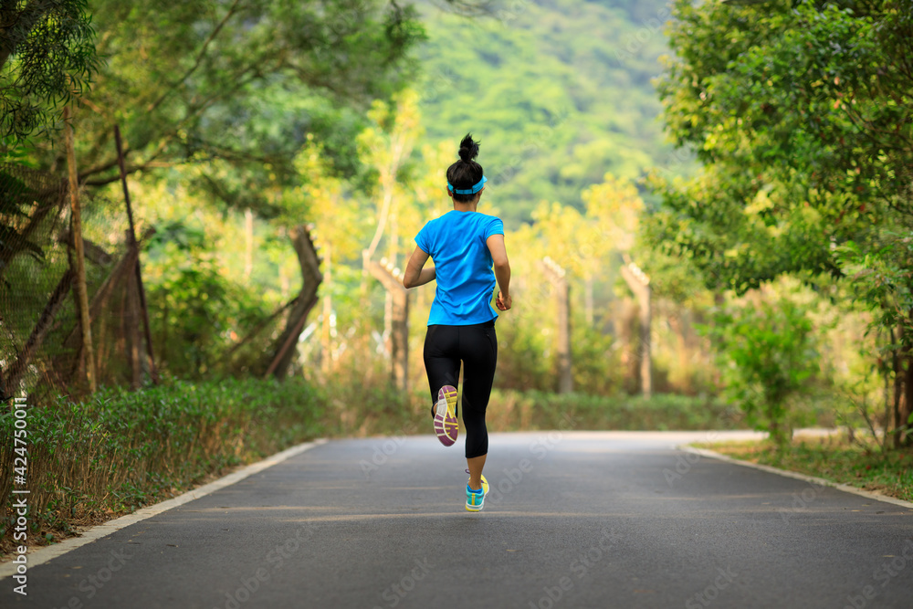 Fitness woman running on forest trail Fitness woman running on forest trail