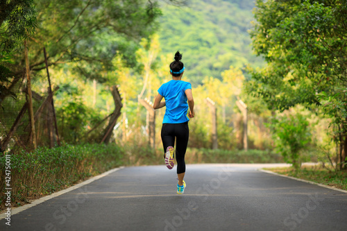 Fitness woman running on forest trail