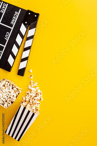 Layout of film reel with popcorn and clapperboard. Cinema concept photo