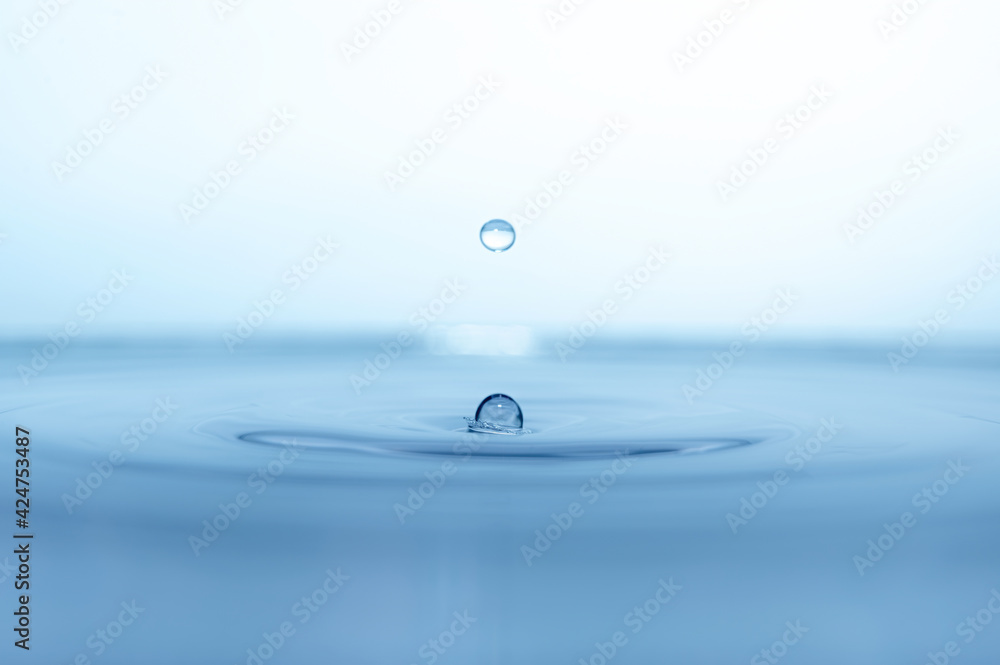 water drop splash in a glass blue colored water drop splash in a glass blue colored