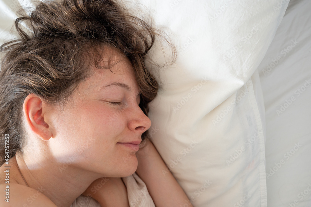 Young caucasian woman sleeping in bed. Cosy pillow and sleeping woman. Dream and relax concept Young caucasian woman sleeping in bed. Cosy pillow and sleeping woman. Dream and relax concept
