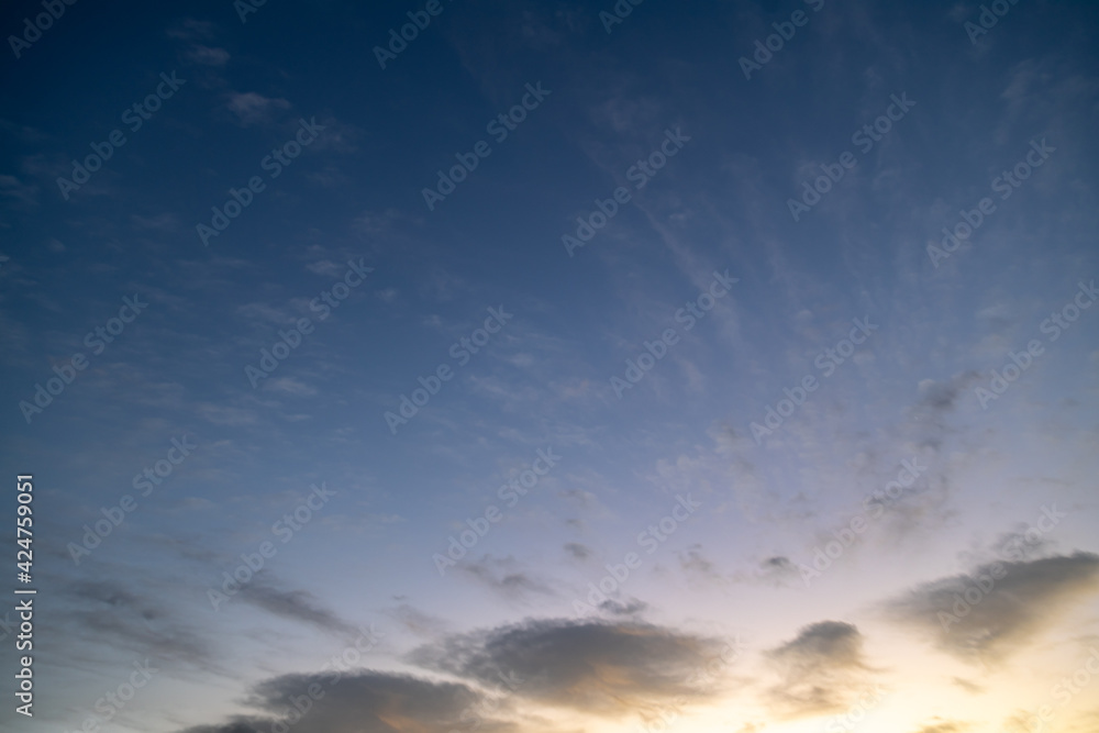 Obraz premium Dusk night sky background. Sun set over mountains and wind scattered small clouds over the horizon.