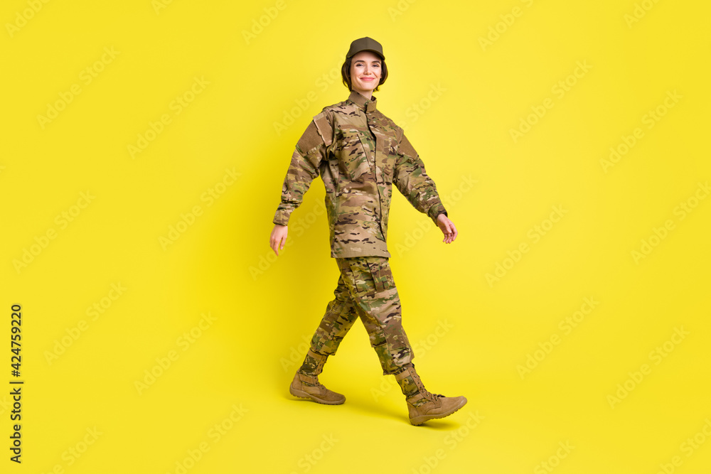 Full length profile portrait of charming friendly person walking look camera isolated on yellow color background Full length profile portrait of charming friendly person walking look camera isolated on yellow color background
