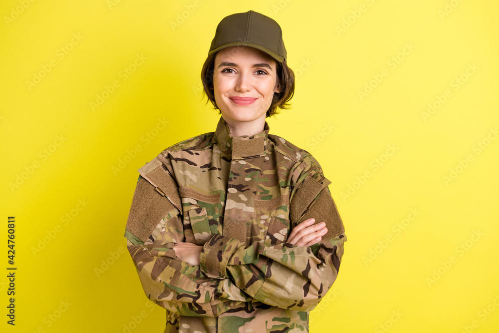 Photo of pretty positive lady folded hands smile look camera wear hat isolated on yellow color background Photo of pretty positive lady folded hands smile look camera wear hat isolated on yellow color background