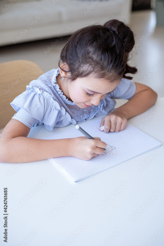 Beautiful young schoolgirl drawing at a white table in her room, home learning concept Beautiful young schoolgirl drawing at a white table in her room, home learning concept