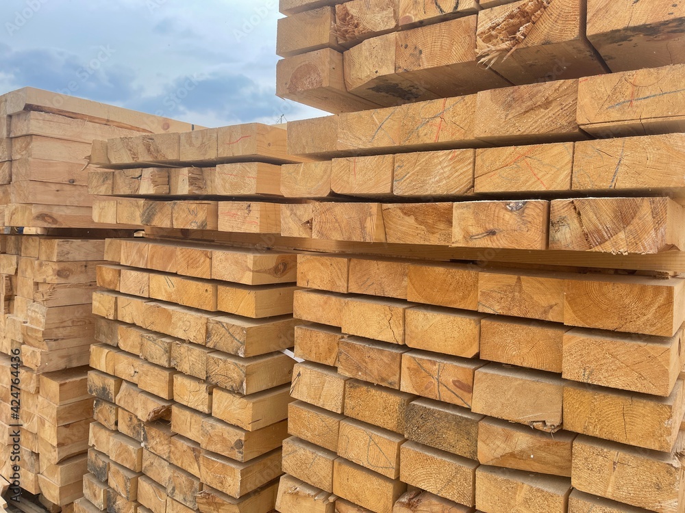 Wooden boards, lumber, industrial wood, timber. Pine wood timber stack of natural rough wooden boards on building site. Industrial timber building materials Wooden boards, lumber, industrial wood, timber. Pine wood timber stack of natural rough wooden boards on building site. Industrial timber building materials