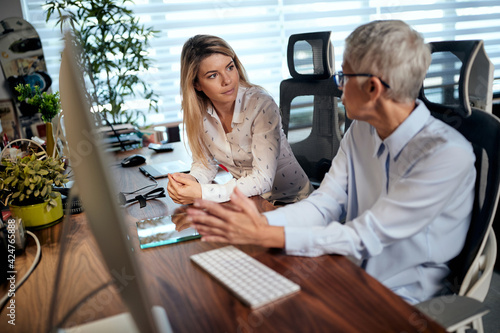 Young woman being mentored by senior successful businesswoman photo