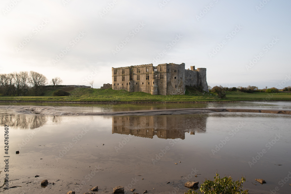View of Carew castle in Pembrokeshire, Wales, UK with reflections on the water