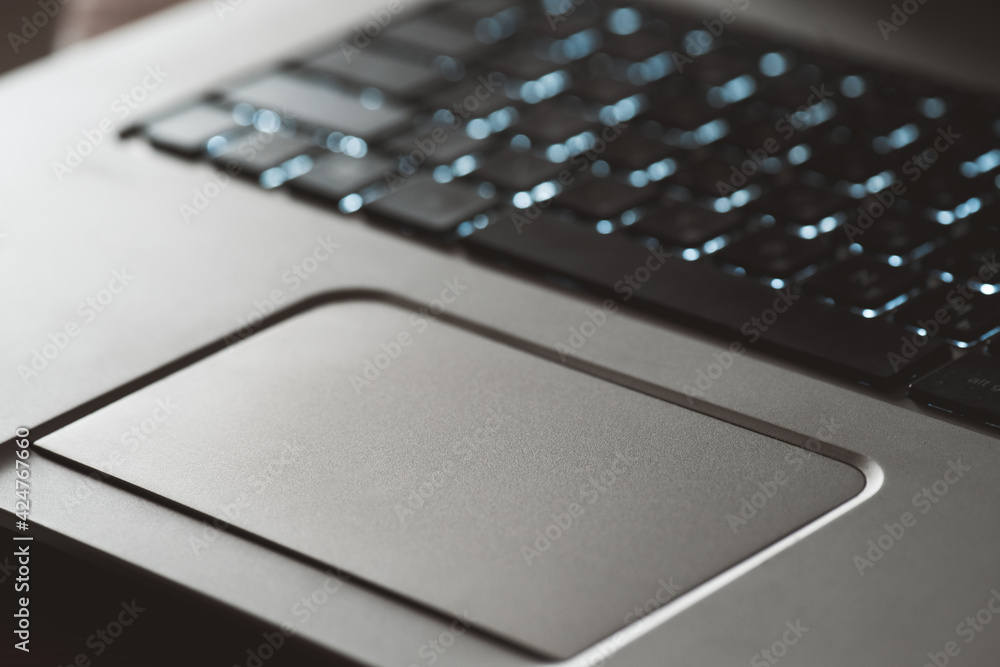 Touch pad of silver laptop close up.