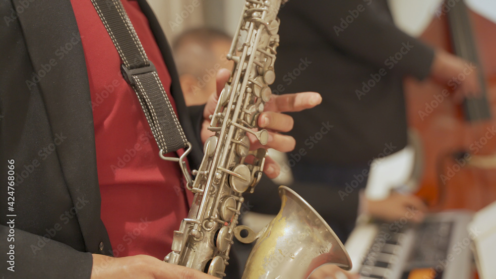 Obraz premium close up asian Saxophonist playing a saxophone on stage performance.