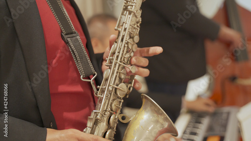 close up asian Saxophonist playing a saxophone on stage performance.