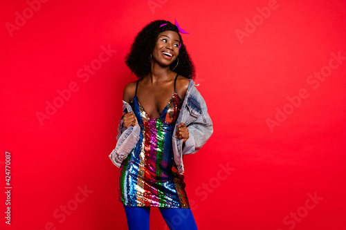 Photo of charming sweet wavy dark skin lady wear pin up outfit dancing looking empty space isolated red color background © deagreez