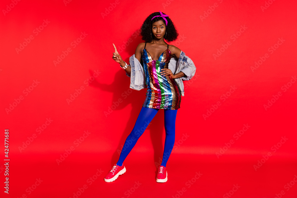 Obraz premium Photo of pretty adorable wavy dark skin lady wear pin up outfit pointing finger empty space isolated red color background
