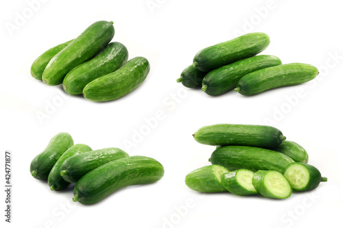 fresh green baby cucumbers you can eat as a snack and some cut ones on a white background