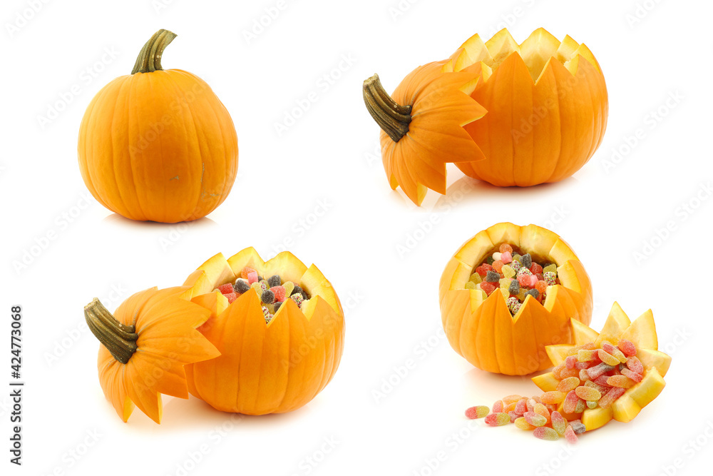 An orange Halloween pumpkin cut open and some filled with candy on a white background An orange Halloween pumpkin cut open and some filled with candy on a white background