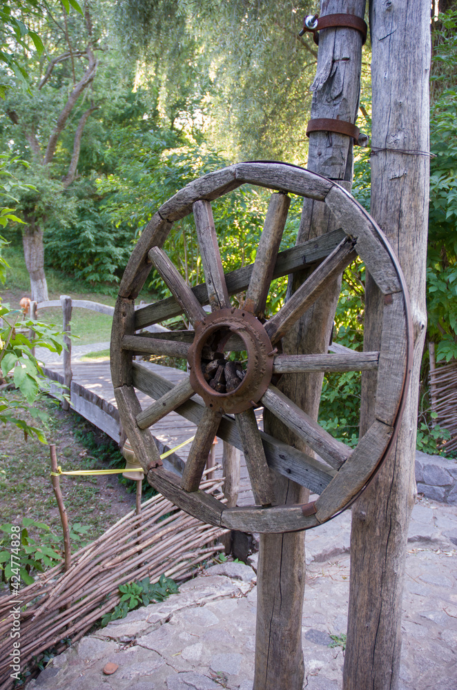 Old wooden wheel from a cart, village traditions Old wooden wheel from a cart, village traditions