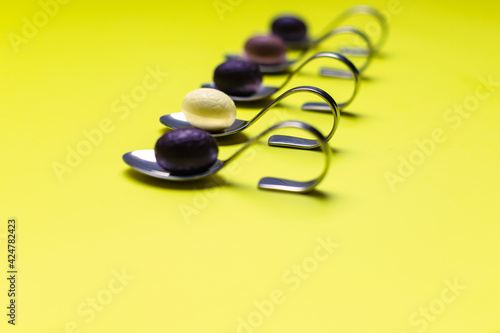 Small chocolate eggs like snack for Easter on yellow background.