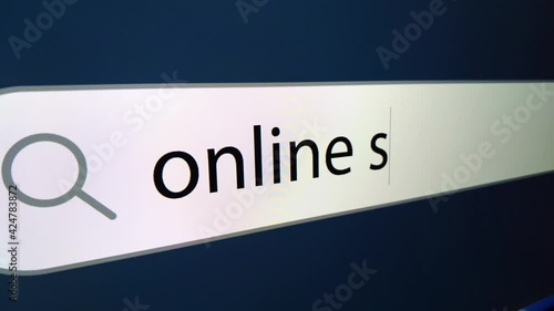 Online shopping written in search bar with cursor, computer monitor, close-up with camera zoom effect. 4k