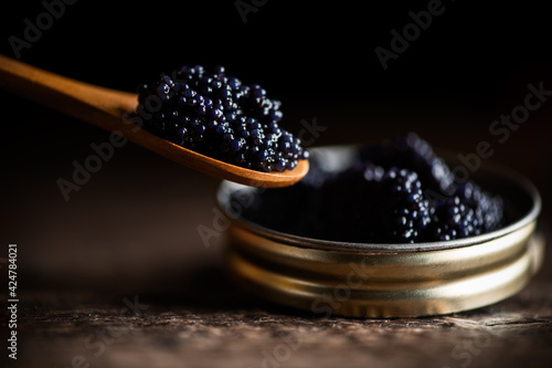 Black lumpfish caviar in a small pot and spoon photo