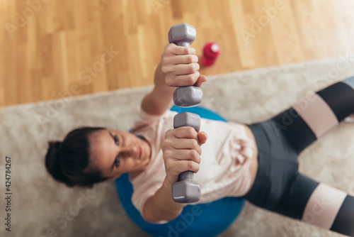 Woman training at home with dumbbells