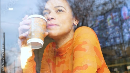 Slow motion young beautiful curly hair black woman sitting cafeteria drinking from reusable cup saying no to plastic