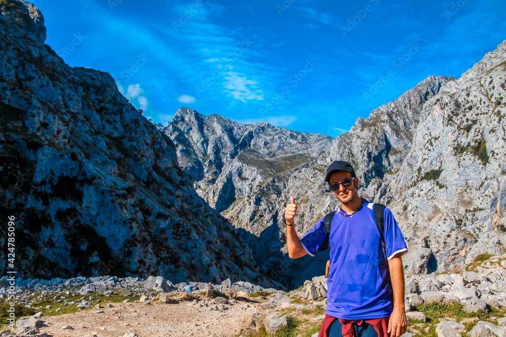 Naklejka premium A young man on the trail in the Picos de Europa, on the Cares route. Asturias
