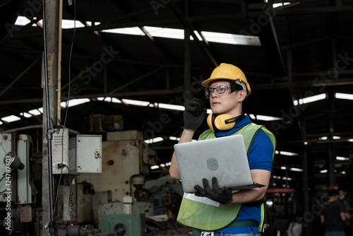 worker working in steel industrial with uniform. worker with computer laptop in hand hold.