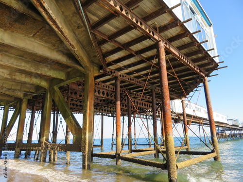 Fototapeta Naklejka Na Ścianę i Meble -  View of underside of wooden and steel pier on the beach