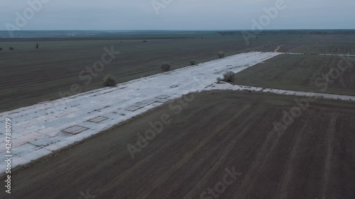 Drone fly above old runway strip on lost military airfield on the endless steppen fields at autumn photo