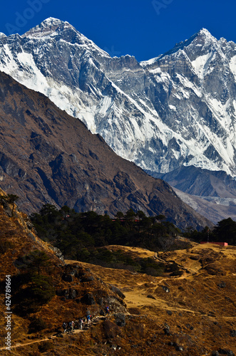 Mount Everest (8.848m) and Lhotse (8.516m), highest and 4th highest mountains in the world, towering above a group of trekkes on the Everest Base Camp Trek, Sagarmatha National Park, Solukhumbu, Nepal